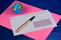 Envelope paper mail, pink paper, pen for writing, globe of the world. Paper mailing envelope with a window for labels, for