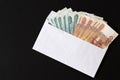 Envelope with ruble bills on black background. Bribe. Stack large ruble banknotes sticking out of white envelope. Concept cash br