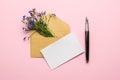 An envelope, a sheet of paper, a fountain pen and a bouquet of flowers on a pink background. Flat lay Royalty Free Stock Photo