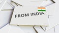 Envelope with From India text on pile of other envelopes. International mail related conceptual 3D rendering