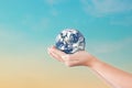 Globe in hands over blue sky background. Save of earth. Royalty Free Stock Photo