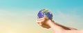 Globe in hands over blue sky background. Save of earth. Royalty Free Stock Photo