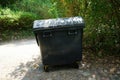 Large garbage bin made of polyethylene plastic with a hinged lid stands in the public area of Sanssouci Park in Potsdam, Germany. Royalty Free Stock Photo