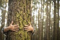 Environment and respect for Earth nature concept - adult woman hugging a green tree in the forest - save the planet and climate Royalty Free Stock Photo