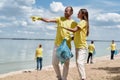 Environmental Activists. Two young man and woman holding trash bag and discussing something while cleaning beach area Royalty Free Stock Photo