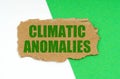 On a white-green background lies a piece of cardboard with the inscription - Climatic anomalies