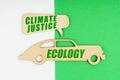 On a white and green background, a wooden figure of a car - Ecology and a sign with the inscription - Climate justice Royalty Free Stock Photo