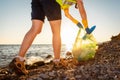 Environmental conservation. Bottom view of woman volunteer picking up garbage at beach. Concept of ocean& x27;s pollution