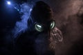 Gas mask with clouds of smoke on a dark background. Sign of radioactive contamination. Means for radiation protection. Danger of Royalty Free Stock Photo