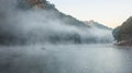 Environmental Friendly Outdoor Activity, Floating Bamboo Rafting in the morning in serene lake with sunlight and mist water Royalty Free Stock Photo