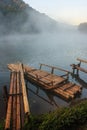 Environmental Friendly Outdoor Activity, Floating Bamboo Rafting in the morning in serene lake with sunlight and misty water Royalty Free Stock Photo