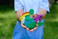 Environmental information and understanding. Child hands holding earth model with clay rainbow Royalty Free Stock Photo