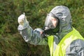 Environmental laboratory specialist in protective suit and mask took a sample of water in a test tube for research, close-up