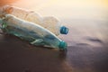 Used plastic bottles on sandy beach at morning or sunset light Royalty Free Stock Photo