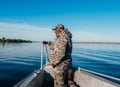 Environmental police officer in a raid to apprehend poachers. A man in camouflage on the bow of a boat.