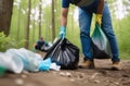 Environmental problems. A man in a protective glove collects plastic garbage in nature, volunteers clean the forest from Royalty Free Stock Photo