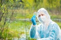 environmentalist in protective clothing examines infected plants