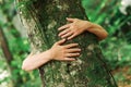 Environmentalist tree hugger is hugging wood trunk in forest Royalty Free Stock Photo