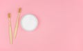 Environmentally friendly personal hygiene products. Wooden toothbrushes and tooth powder on a pink background