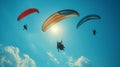 Envision the breathtaking spectacle of people paragliding against a backdrop of endless blue sky, their silhouettes gliding