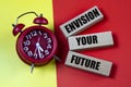 ENVISION YOUR FUTURE - words on colorful background with alarm clock