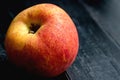 The envy apple on black wooden board after bring out of the refrigerator