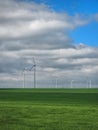 Eolian farm renewable energy in fresh green field against clear blue sky Royalty Free Stock Photo