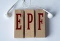 EPF - acronym on wooden blocks on white background with wired headphones Royalty Free Stock Photo