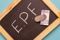EPF or Employee provident Fund written on black slate with Indian Currency notes and Coin Royalty Free Stock Photo