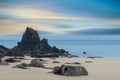 Epic beautiful sunrise long exposure landscape of vibrant sky over calm rocky sand beach