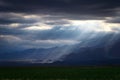 Epic, dramatic sunrays seeping through the clouds over the Andes Mountains in Mendoza, Argentina, on a dark, cloudy day Royalty Free Stock Photo