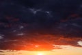 Epic sunset, sunrise on storm sky with dark clouds, orange yellow red sun and sunlight background texture Royalty Free Stock Photo