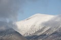 Epic landscape image of Skiddaw snow capped mountain range in Lake District in Winter with low level cloud around peaks viewed Royalty Free Stock Photo