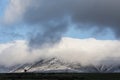 Epic landscape image of Skiddaw snow capped mountain range in Lake District in Winter with low level cloud around peaks viewed Royalty Free Stock Photo