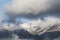 Epic landscape image of Skiddaw snow capped mountain range in Lake District in Winter with low level cloud around peaks viewed Royalty Free Stock Photo