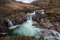 Epic landscape image of vibrant River Coe flowing beneath snowcapped mountains in Scottish Highlands