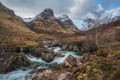 Epic landscape image of vibrant River Coe flowing beneath snowcapped mountains in Scottish Highlands