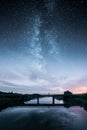 Epic milky way with a silhouette of a man walking on a bridge Royalty Free Stock Photo
