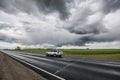 Epic sky, fast moving car on the road Royalty Free Stock Photo