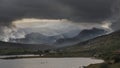 Epic stunning Autumn landscape image of Snowdon Massif viewed from shores of Llynnau Mymbyr at sunset with dramatic dark sky and Royalty Free Stock Photo