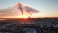 Epic sunset on the background of a Smoking factory. The red sun with bright rays goes beyond the pipe factories and smog.