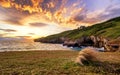 An epic sunset with dramatic burning clouds in Tunnel Beach of Dunedin, New Zealand Royalty Free Stock Photo