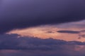 Epic sunset storm sky. Big dark violet cumulus thunderstorm clouds in yellow orange sunlight background texture Royalty Free Stock Photo