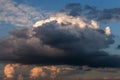 Epic sunset storm sky. Big white and dark grey cumulus thunderstorm rainy clouds in yellow orange sunlight on blue sky Royalty Free Stock Photo