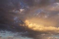 Epic sunset storm sky. Big white grey cumulus thunderstorm clouds in yellow orange sunlight on blue sky background Royalty Free Stock Photo