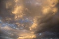 Epic sunset storm sky. Big white grey cumulus thunderstorm clouds in yellow orange sunlight on blue sky background texture Royalty Free Stock Photo