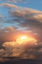 Epic sunset storm sky with sun and yellow orange sunlight. Big dark fluffy cumulus clouds on blue sky background texture Royalty Free Stock Photo