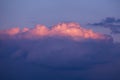 Epic sunset sunrise sky with pink big fluffy cumulus cloud in sunlight on blue sky background texture Royalty Free Stock Photo
