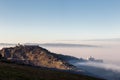 An epic view of St.Francis church in Assisi town Umbria above a sea of fog at dawn Royalty Free Stock Photo