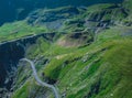 Epic winding road on Transfagarasan pass in Romania in summer time, with twisty road rising up. Road crossing Fagaras mountain